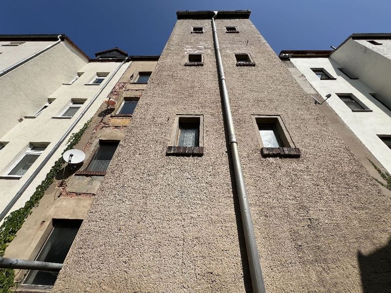Fünfgeschossiges Wohnhaus mit grauer Putzfassade und regelmäßigen Fensterreihen, Käthe-Kollwitz-Straße in Altenburg