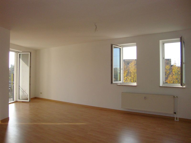 Leeres Wohnzimmer mit Holzparkett, hellen Wänden, zwei Fenster zur Engertstraße in Leipzig-Lindenau, Heizkörper