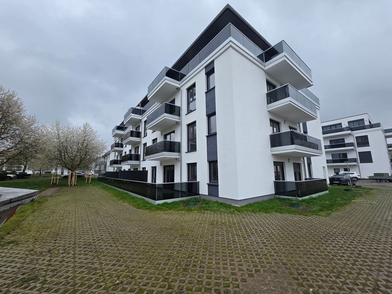 Modernes viergeschossiges Wohngebäude mit weißer Fassade, schwarzen Akzenten und Balkonen, Rotdornstraße in Leipzig-Paunsdorf