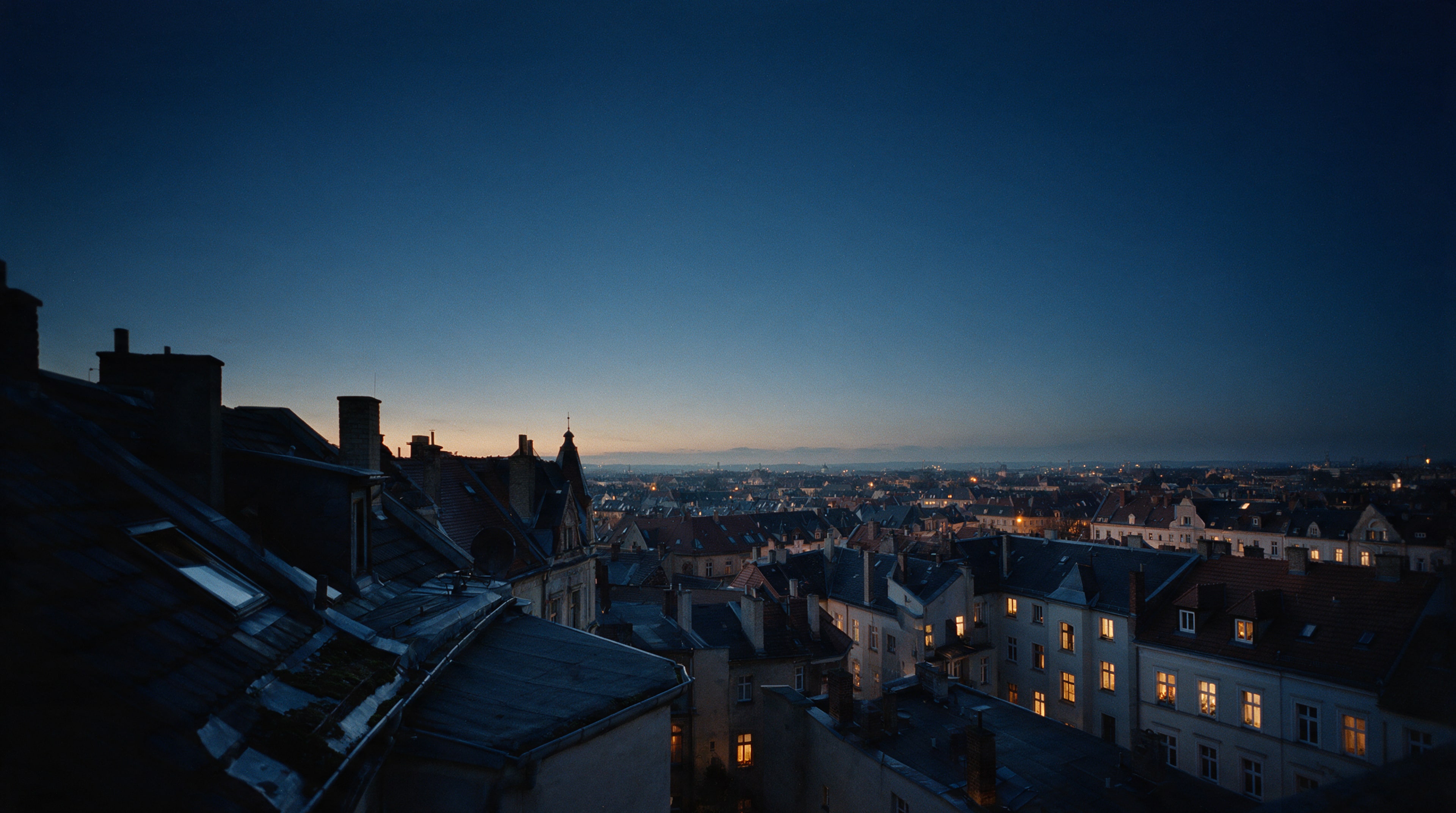 Blick über die Dächer eines Gründerzeitviertels in Leipzig zur blauen Stunde